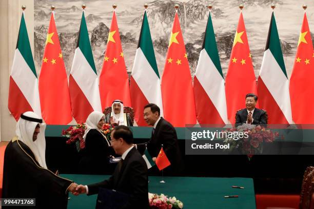Kuwait's ruling emir, Sheikh Sabah Al Ahmad Al Sabah and Chinese President Xi Jinping applaud as they witness a signing ceremony at the Great Hall of...