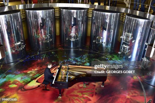 Russian pianist Nikolai Lougansky plays inside the new cuvier of the Chateau La Grace Dieu des Prieurs estate during its inauguration on July 5, 2018...