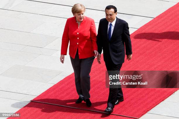 German Chancellor Angela Merkel and Chinese Premier Li Keqiang walk to the honor guard during the welcome ceremony at the Chancellery on July 9, 2018...