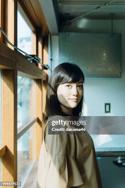 junge frau ein fenster. - asiatischer volksstamm stock-fotos und bilder