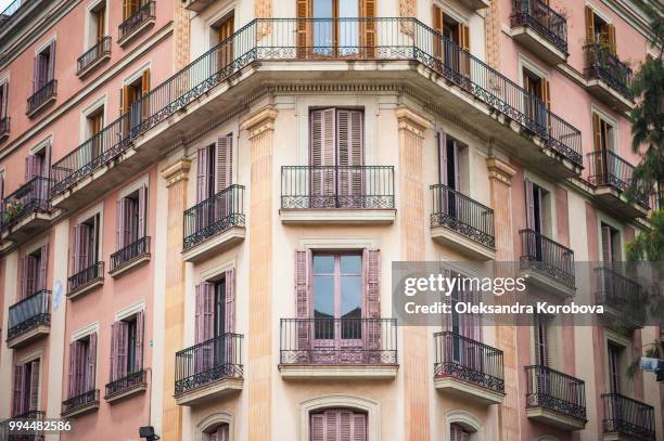 intricate iron work balconies, wooden shutters and sculptural building details on the narrow streets of barcelona, spain. - calle urbana imagens e fotografias de stock