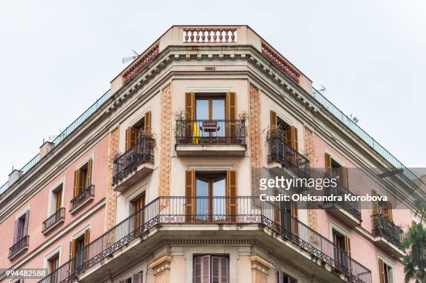 intricate iron work balconies, wooden shutters and sculptural building details on the narrow streets of barcelona, spain. - calle stockfoto's en -beelden