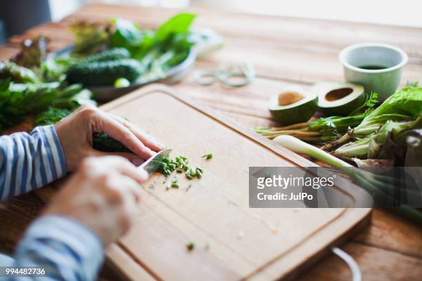 woman cutting herbs and vegetables - cutting board stock pictures, royalty-free photos & images