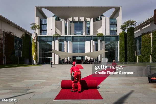Workers prepare the red carpet before the military honors for the German Chancellor Angela Merkel and Li Keqiang , Prime Minister of China, on July...