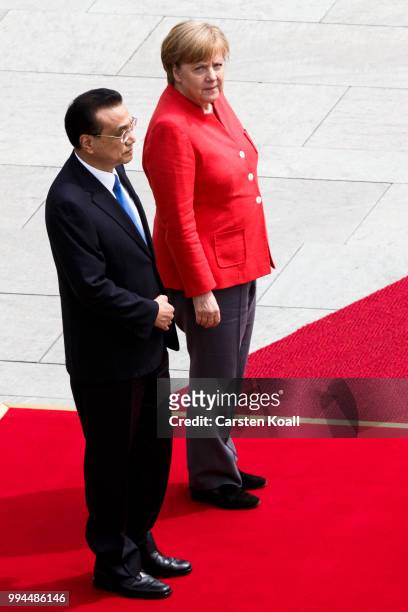 German Chancellor Angela Merkel and Chinese Premier Li Keqiang prepare to review an honor guard at the Chancellery on July 9, 2018 in Berlin,...