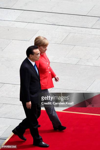 German Chancellor Angela Merkel and Chinese Premier Li Keqiang prepare to review an honor guard at the Chancellery on July 9, 2018 in Berlin,...