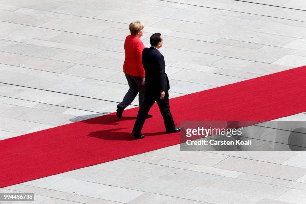 German Chancellor Angela Merkel and Chinese Premier Li Keqiang walk to review an honor guard at the Chancellery on July 9, 2018 in Berlin, Germany....