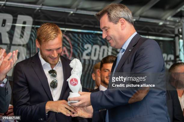 July 2018, Germany, Nuremberg: Markus Soeder of the Christian Social Union , Premier of Bavaria, hands Hanno Behrens, player of the German Bundesliga...