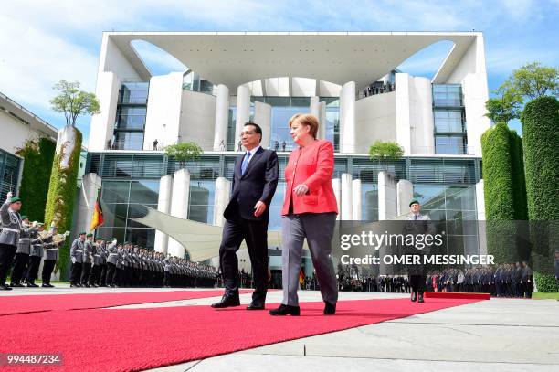 German Chancellor Angela Merkel and Chinese Premier Li Keqiang review a military honor guard during a welcoming ceremony at the Chancellery in Berlin...