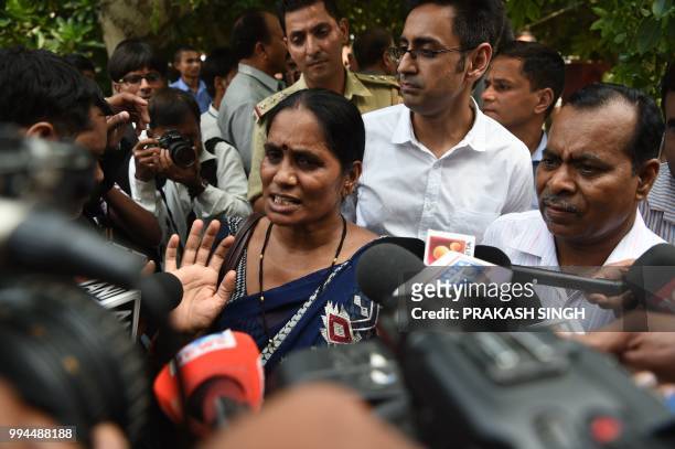Asha Singh, the mother , and Badrinath Singh, the father of a woman who was killed after a gang-rape in 2012, talk to the media outside India's...