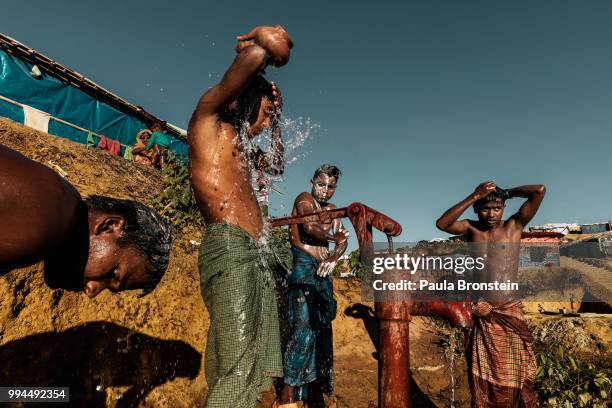 Men wash themselves at a communal water pump in Kutupalong refugee camp. The sanitary conditions in the refugee camps are poor, latrines and tube...