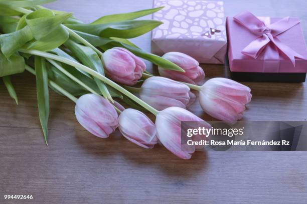 close-up of bouquet of tulips flowers and gift boxes on wooden background. selective focus. - rz stock pictures, royalty-free photos & images