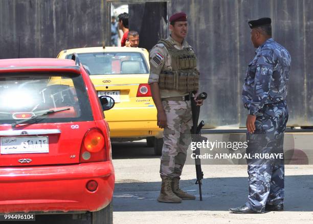 Members of the Iraqi security forces stand guard outside a warehouse where ballots from the May parliamentary election are stored in the capital...