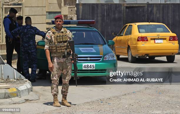 Members of the Iraqi security forces stand guard outside a warehouse where ballots from the May parliamentary election are stored in the capital...