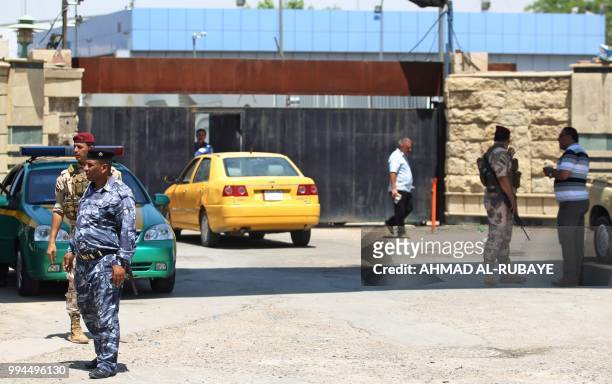 Members of the Iraqi security forces stand guard outside a warehouse where ballots from the May parliamentary election are stored in the capital...