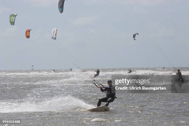 Trendsport kite surfing on the North sea coast in St. Peter Ording and the concerns about the habitat of the birds on this strech of coast in the...