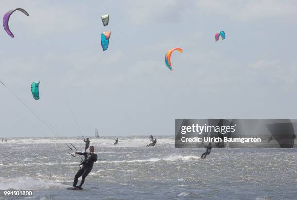 Trendsport kite surfing on the North sea coast in St. Peter Ording and the concerns about the habitat of the birds on this strech of coast in the...