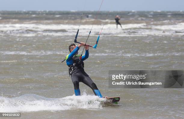Trendsport kite surfing on the North sea coast in St. Peter Ording and the concerns about the habitat of the birds on this strech of coast in the...