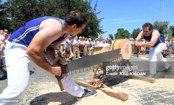 Participants saw a tree trunk with a "tronza", a traditional Basque saw, during a rural Basque sports championship on the third day of the San Fermin...