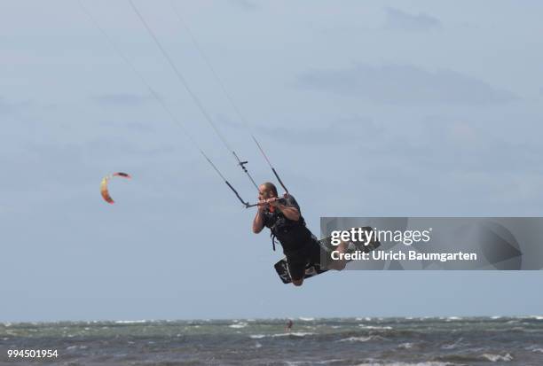 Trendsport kite surfing on the North sea coast in St. Peter Ording and the concerns about the habitat of the birds on this strech of coast in the...