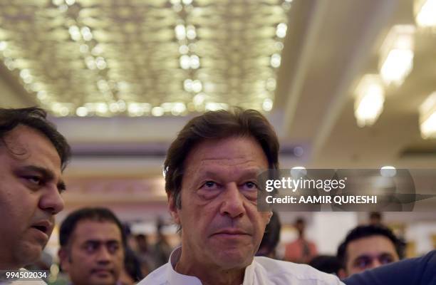 Pakistani cricketer-turned-politician and head of the Pakistan Tehreek-i-Insaf Imran Khan looks on before presenting their party manifesto for the...