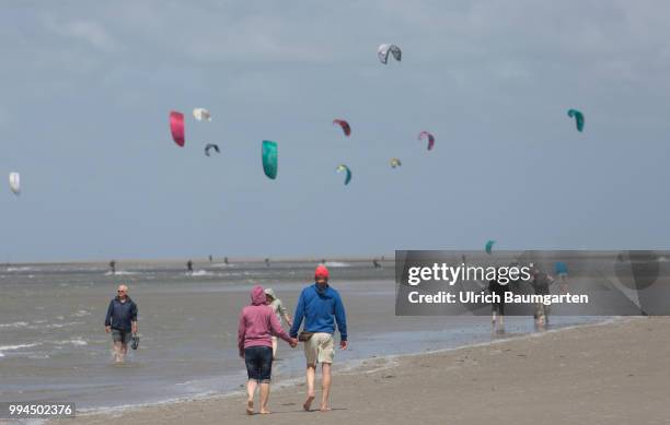 Trendsport kite surfing on the North sea coast in St. Peter Ording and the concerns about the habitat of the birds on this strech of coast in the...