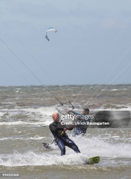 Trendsport kite surfing on the North sea coast in St. Peter Ording and the concerns about the habitat of the birds on this strech of coast in the...