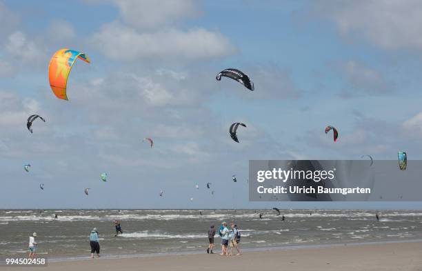 Trendsport kite surfing on the North sea coast in St. Peter Ording and the concerns about the habitat of the birds on this strech of coast in the...