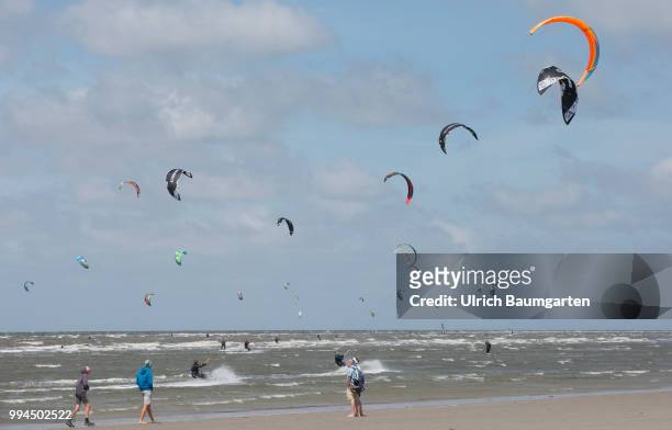 Trendsport kite surfing on the North sea coast in St. Peter Ording and the concerns about the habitat of the birds on this strech of coast in the...