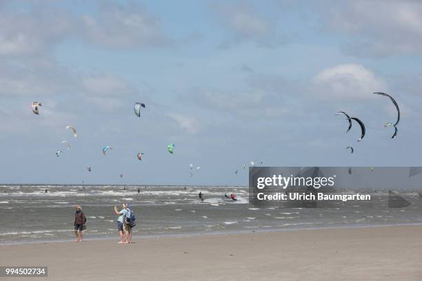 Trendsport kite surfing on the North sea coast in St. Peter Ording and the concerns about the habitat of the birds on this strech of coast in the...