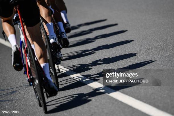 Shadows of riders of Great Britain's Team Sky cycling team are cast on the route during a training session, prior to the third stage of the 105th...