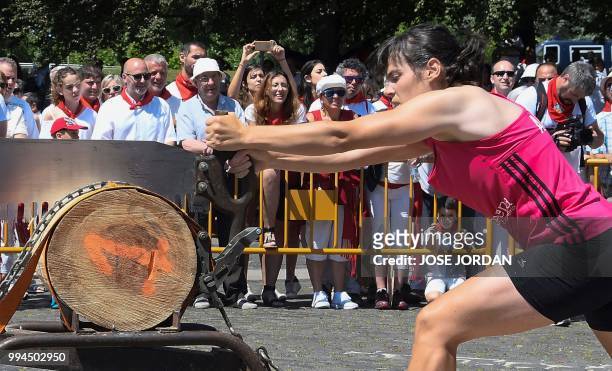 Participant saws a tree trunk with a "tronza", a traditional Basque saw, during a rural Basque sports championship on the third day of the San Fermin...