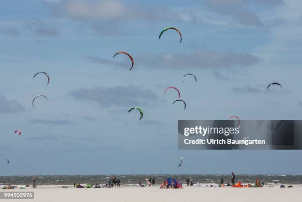 Trendsport kite surfing on the North sea coast in St. Peter Ording and the concerns about the habitat of the birds on this strech of coast in the...