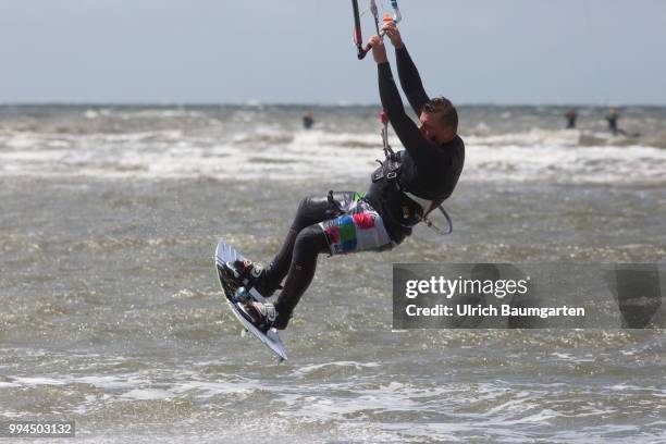 Trendsport kite surfing on the North sea coast in St. Peter Ording and the concerns about the habitat of the birds on this strech of coast in the...