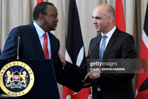 Swiss President Alain Berset speaks with his Kenyan counterpart President Uhuru Kenyatta during a joint press conference at the State House in...