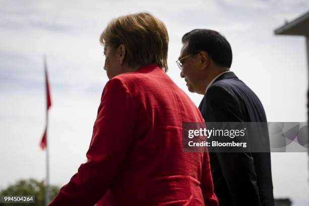 Angela Merkel, Germany's chancellor, left, and Li Keqiang, China's premier, review an honor guard as he arrives at the Chancellery building in...