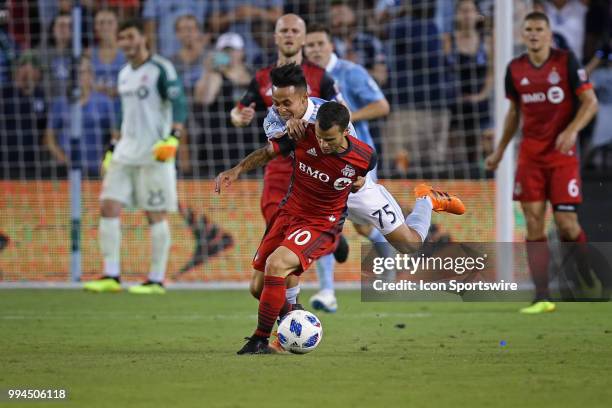 Sporting Kansas City midfielder Wan Kuzain grabs Toronto FC forward Sebastian Giovinco from behind in the second half of an MLS match between Toronto...