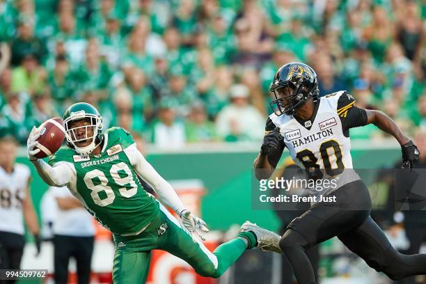 Duron Carter of the Saskatchewan Roughriders nearly intercepts a pass intended for Terrence Toliver of the Hamilton Tiger-Cats in the first half of...