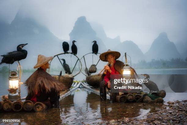 traditionelle chinesische fischer eine pause auf bambus-floß - pfeife natur stock-fotos und bilder