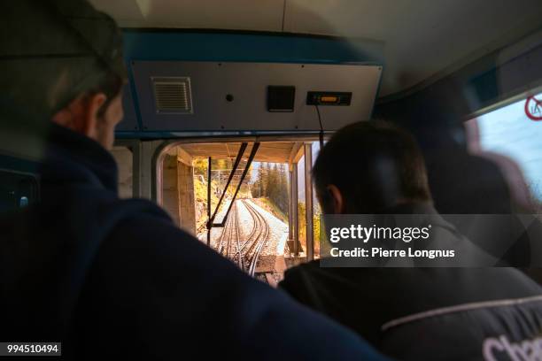 2 non-recognizable train engineers in the cab of train going towards the montenvers upper station at the "mer de glace" (sea of ice) glacier - chamonix train stockfoto's en -beelden