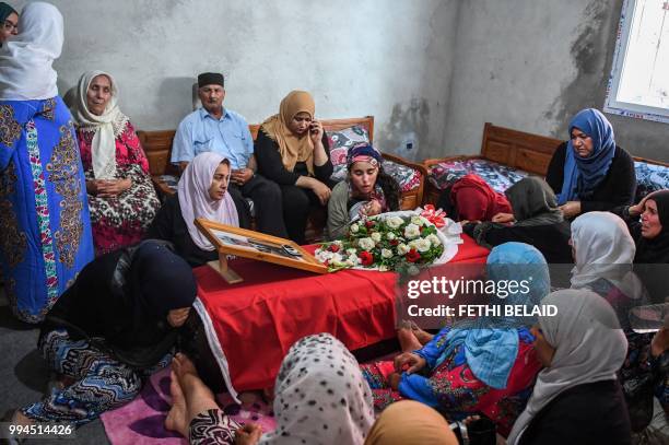 Relatives of killed Tunisian police officer Sgt. Arbi Guizani mourn over his coffin in their home in capital Tunis' northwestern suburb of Ettadhamen...