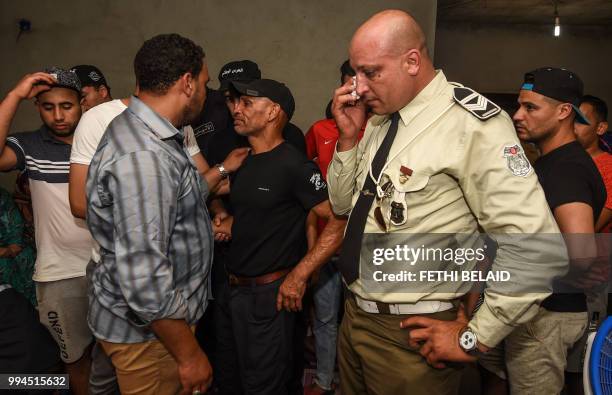 Relatives and colleagues of killed Tunisian police officer Sgt. Arbi Guizani react as they mourn during his funeral in the capital Tunis'...