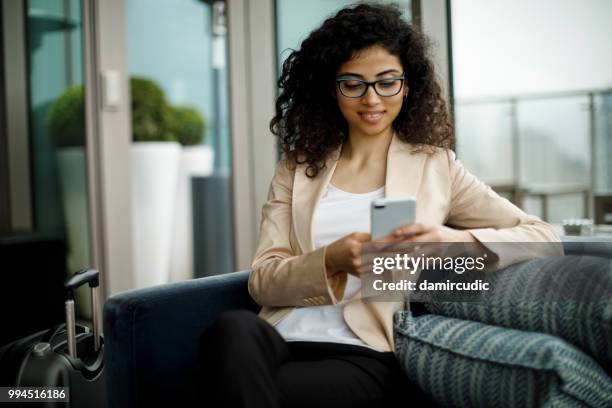 businesswoman using mobile phone at rooftop cafe - damircudic stock pictures, royalty-free photos & images