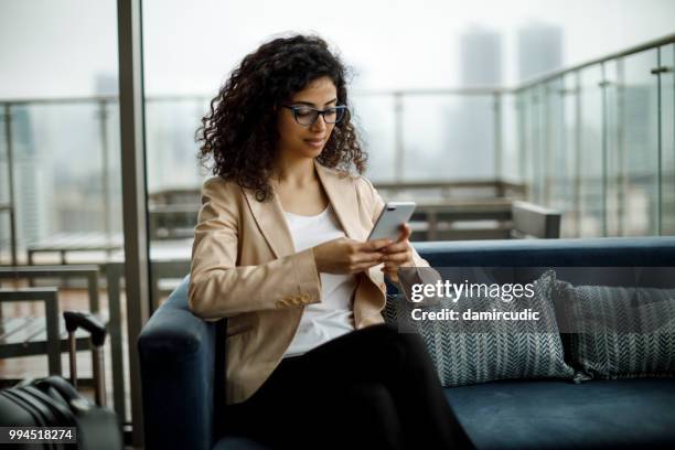 businesswoman staying in touch with her clients on business trip - damircudic stock pictures, royalty-free photos & images