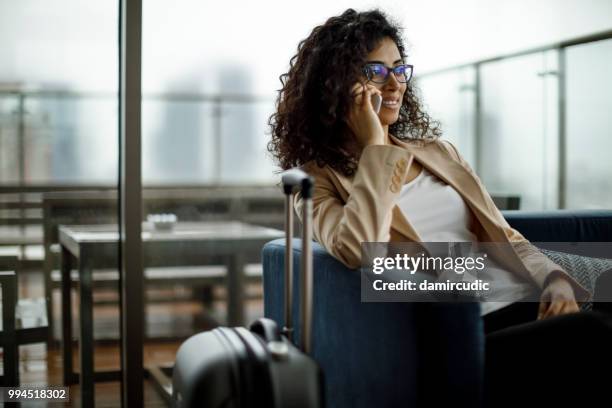 businesswoman using mobile phone at a cafe - airport vip lounge stock pictures, royalty-free photos & images