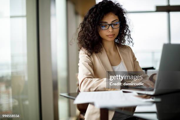 businesswoman working on laptop at a cafe - damircudic stock pictures, royalty-free photos & images