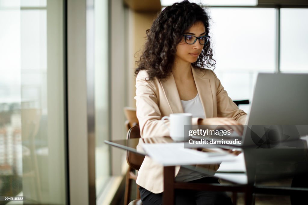 Jonge zakenvrouw werken op de laptop in een café