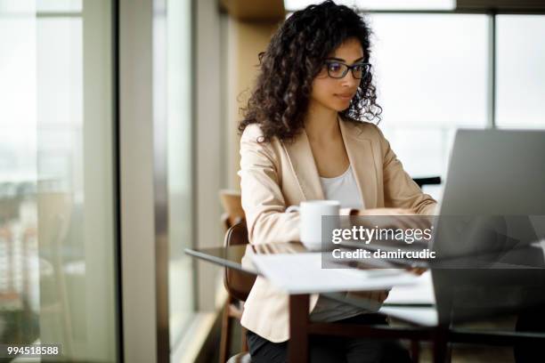 jonge zakenvrouw werken op de laptop in een café - hispanic woman computer stockfoto's en -beelden