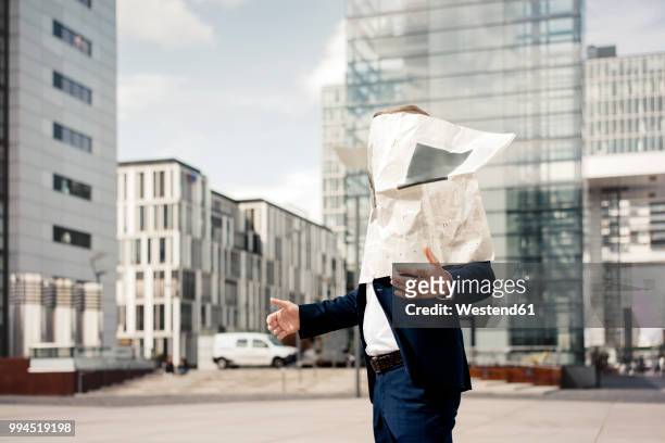 newspaper covering businessman's face in the city - wind storm stock pictures, royalty-free photos & images