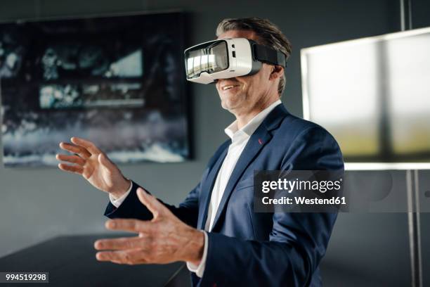 mature businessman wearing vr glasses in office - virtual reality 個照片及圖片檔